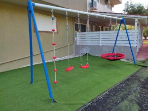 a play area with swings on a lawn at Christos House in Neos Marmaras