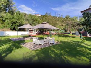a table and chairs under umbrellas in a yard at Christos House in Neos Marmaras