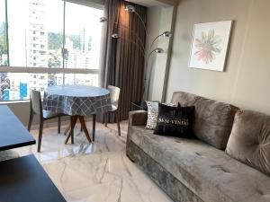 a living room with a couch and a table at "Conforto e Bem Estar" Próximo da praia in Balneário Camboriú