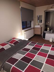 a bedroom with a large bed and a bathroom at Heaven in Aan de Wolfsberg