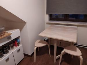 a small kitchen with a wooden table and two stools at Heaven in Aan de Wolfsberg