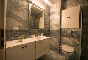 ein Badezimmer mit Waschbecken, Toilette und Spiegel in der Unterkunft Apartel Marina in Mamaia Nord – Năvodari + 16 Fotos