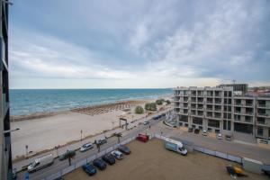 Blick auf den Strand, ein Gebäude und das Meer in der Unterkunft Apartel Marina in Mamaia Nord – Năvodari
