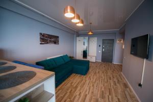 ein Wohnzimmer mit einer blauen Couch und einem Fernseher in der Unterkunft Apartel Marina in Mamaia Nord – Năvodari