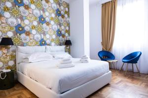 Un dormitorio con una cama blanca y una pared con placas. en Hotel Cinquantatre, en Roma