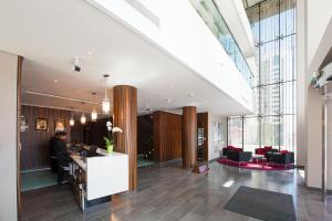 an office lobby with a person sitting at a desk at Centro Al Manhal by Rotana in Abu Dhabi +37 photos
