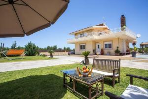 a house with a table and a bench in the yard at Laylande House in Theologos