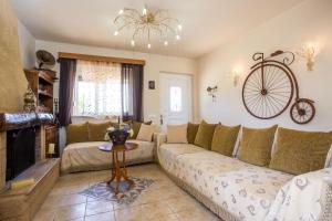 a living room with a couch and a bike on the wall at Laylande House in Theologos