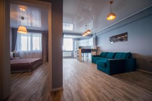 ein Wohnzimmer mit einer blauen Couch und einer Küche in der Unterkunft Apartel Marina in Mamaia Nord – Năvodari