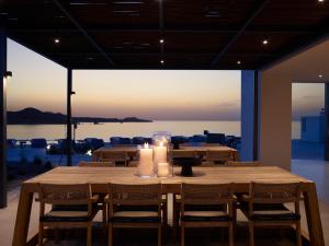 a large wooden table with candles on top of it at Domes White Coast Milos, Adults Only - Small Luxury Hotels of the World in Mytakas