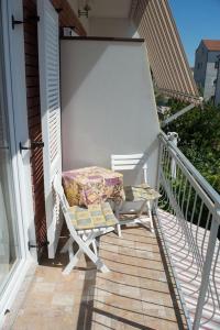 une chaise assise sur la terrasse couverte d'une maison dans l'établissement Apartment in Vodice with balcony, air conditioning, WiFi, washing machine (4266-1), à Vodice