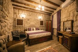 a bedroom with a bed and a chair in a room at Göreme Rock Cave in Göreme