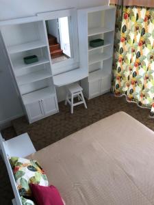 1 dormitorio con estantes blancos y espejo en LA COLLINE DU LAGON en Le François