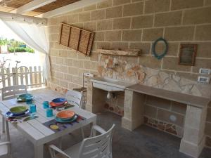 - une cuisine avec une table et un mur en pierre dans l'établissement L'Ulivo del Marchese, à Mandurie