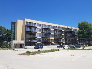 a large building with cars parked in a parking lot at ALFA BETA RESIDENCE in Saturn