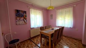 a dining room with pink walls and a table and chairs at Veronika Guesthouse in Drávatamási