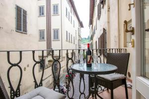 a balcony with a table and chairs on a city street at Casa Michelangelo & Giotto - Tintori apt in Florence