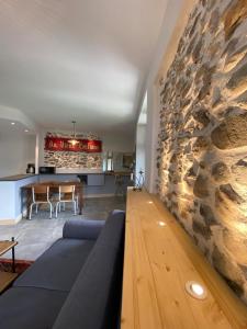 uma sala de estar com um sofá e uma parede de pedra em Tour Ramus- appartements em Albertville