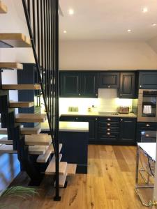 a kitchen with black cabinets and a spiral staircase at Castle Nook in Kelso