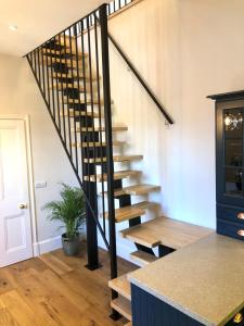 a spiral staircase in a home with a potted plant at Castle Nook in Kelso