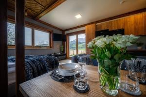 a table with a vase of white flowers on it at Apartamenty Rezydencja Karpielówka in Kościelisko