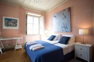 ein Schlafzimmer mit einem großen Bett mit blauer Bettwäsche in der Unterkunft Casa de Santa Teresa in Estoril