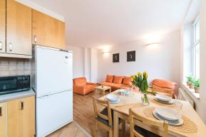 a kitchen and dining room with a table and a white refrigerator at Przyjazne mieszkanie w kamienicy blisko centrum in Wrocław