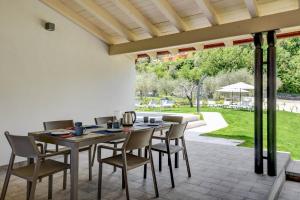 een eetkamer met een tafel en stoelen op een terras bij Le Casette - Leccino in Toscolano Maderno