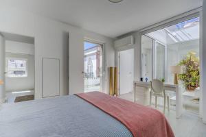 une chambre avec un lit et un bureau avec une chaise dans l'établissement Casa Trindade, encanto no coração de Tavira, à Tavira