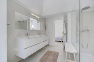 une salle de bain blanche avec lavabo et douche dans l'établissement Casa Trindade, encanto no coração de Tavira, à Tavira 15 autres photos