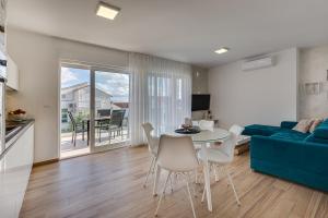 a living room with a blue couch and a table and chairs at Apartments Corcovado with Heated Pool in Vodice