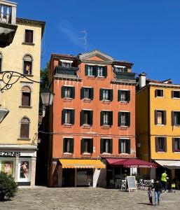 un edificio alto en una ciudad con gente caminando delante de él en Hotel San Geremia, en Venecia