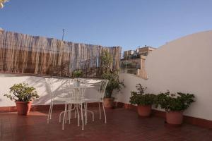 バルセロナにあるLovely apartment with a terraceの鉢植えの植物があるバルコニー(テーブル、椅子付)