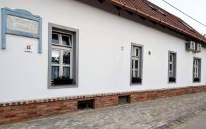 a white building with windows on the side of it at Klára-Háza Vendégház in Tiszadorogma