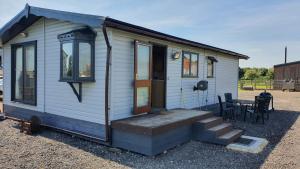 a tiny house with a porch and a staircase at Huntersfield Chalet in Faringdon
