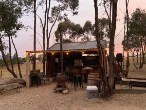eine Hütte mit einem Tisch, Stühlen und einem Baum in der Unterkunft Yeoy's Cabin in Tallarook