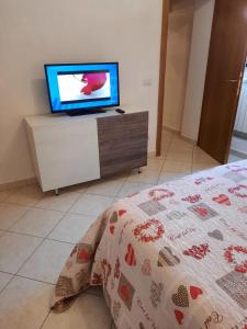 una camera con letto e TV su un comò di Foresteria Guest House a Gaiole in Chianti