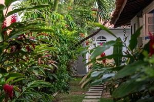 un jardin avec des fleurs et des plantes à côté d'une maison dans l'établissement Bada Hostel & Kite School, à Cumbuco