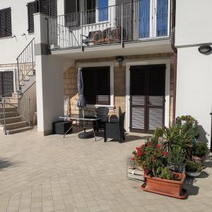 een terras met een tafel, stoelen en planten bij Mololocale in centro a Marcelli in Marcelli
