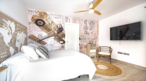 una camera con un letto bianco e una mappa sul muro di Etti - Paradise Suite El Explorador a Pájara