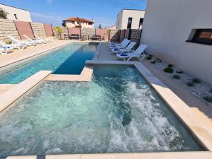 a swimming pool with chaise lounge chairs and a swimming pool at PINNA RESIDENCE - VANGA in Pula