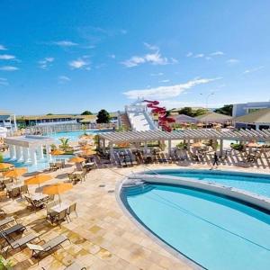 カルダス・ノバスにあるLacqua diroma Caldas Novas Park aquático 24h com cozinha Rのリゾートの隣にある椅子とパラソルのあるプール