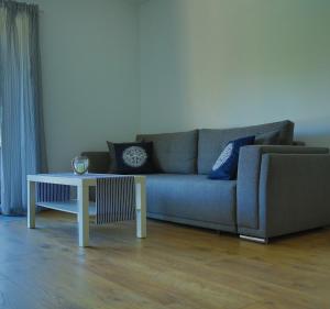 a living room with a couch and a table at Baltic Sea Apartment in Dziwnówek