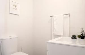 um banheiro branco com um vaso sanitário e uma pia em Casas Peralta - Marialva em Arouca