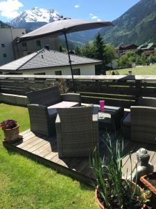 eine Terrasse mit einem Tisch, Stühlen und einem Sonnenschirm in der Unterkunft Waldhaus Lechner Steinerkogel in Mayrhofen