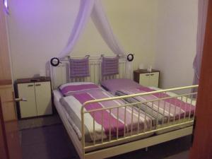 a bedroom with two beds with purple sheets at Waldoase-Appartement im Tannenhof in Haidmühle