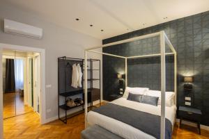a bedroom with a canopy bed with a gray wall at CA’MILLA Luxury Apartments Trieste in Trieste
