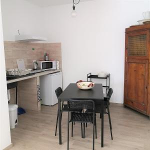 een zwarte tafel en stoelen in een keuken met een magnetron bij Mololocale in centro a Marcelli in Marcelli