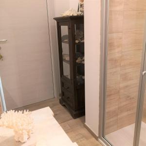 een inloopdouche met een spiegel en een kast bij Mololocale in centro a Marcelli in Marcelli