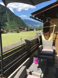 eine Veranda mit einem Stuhl und einem Feld in der Unterkunft Waldhaus Lechner Steinerkogel in Mayrhofen